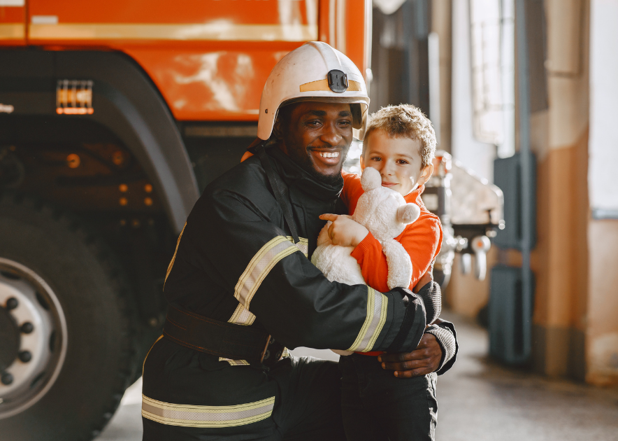 Kid standing next to firefighter